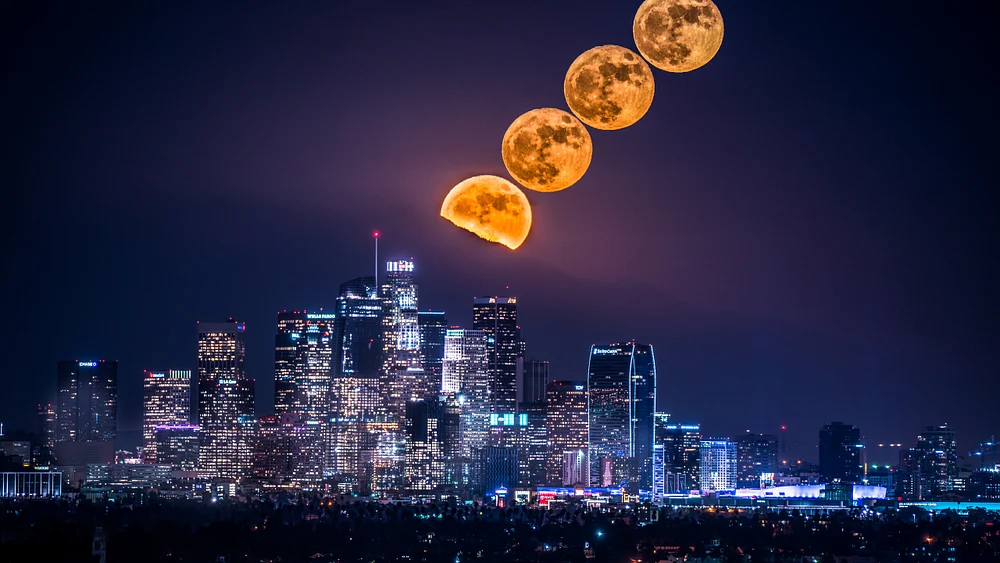A series of full moon phases rising over the skyline of Downtown Los Angeles at night, showcasing the contrast between the moon's glow and the city's lights.