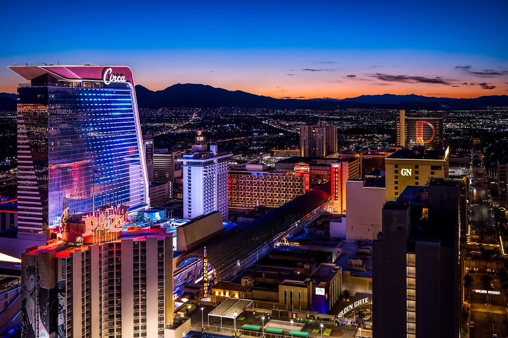 A stunning view of the Las Vegas skyline at dusk, featuring the Circa Resort and Casino illuminated against a colorful sunset backdrop.