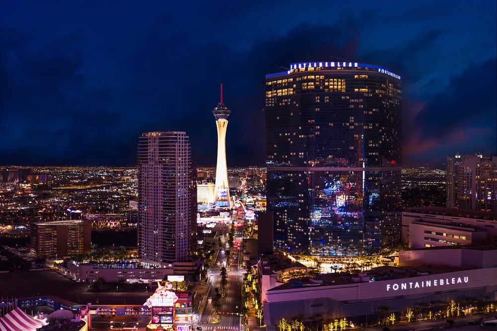 Night view of the Las Vegas Strip featuring the Stratosphere and Fontainebleau hotel, showcasing the vibrant city lights and skyline.