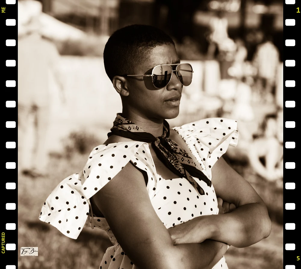 Stylish Woman with Polka Dot Dress and Sunglasses Confident woman in polka dot dress and sunglasses standing with arms crossed.