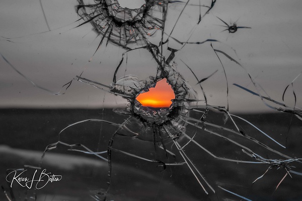 Sunset through a bullet hole in B&amp;W