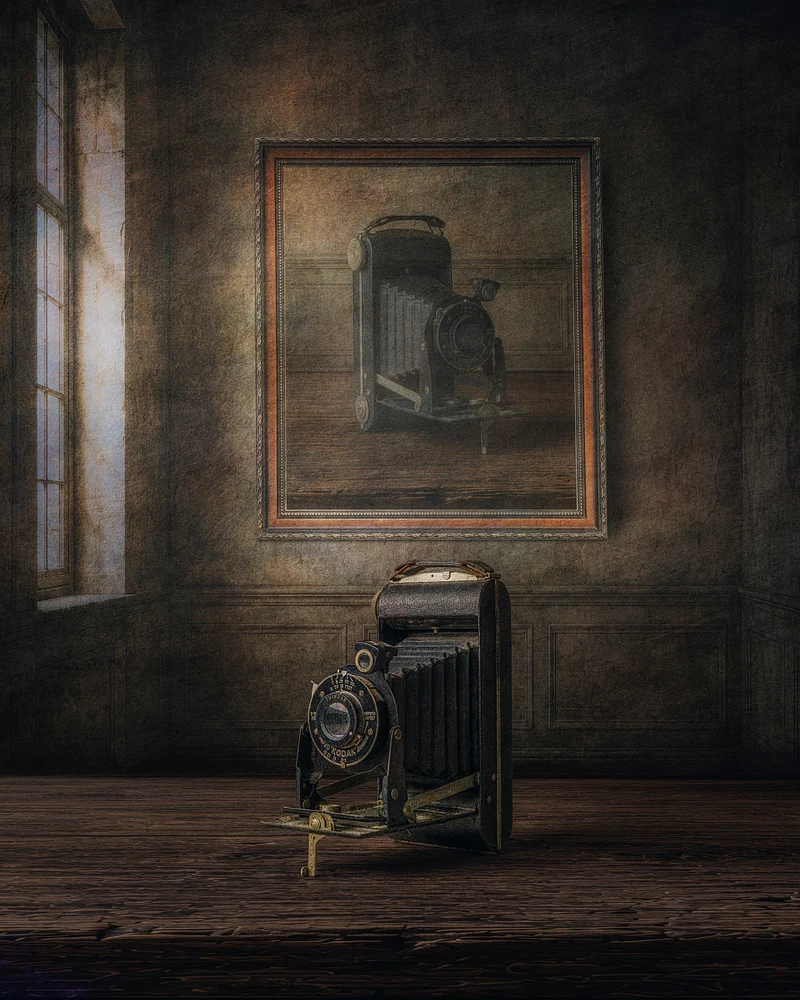 The Keeper of Memories by Marko Klavs, a fine art still life photograph of a vintage folding camera placed before its framed portrait in a timeless historic interior, illuminated by soft window light.