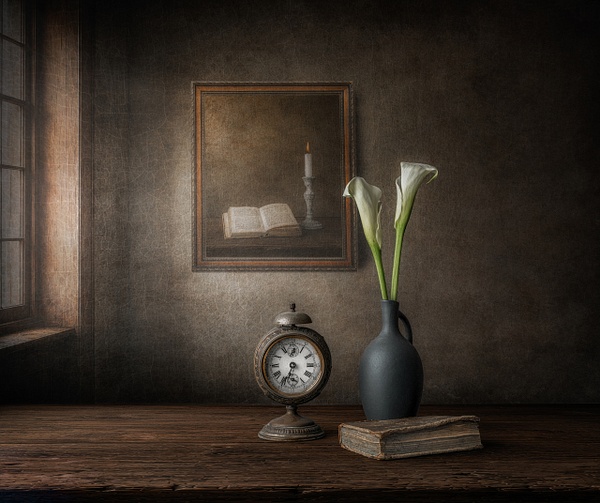 The Measure of Silence by Marko Klavs, a fine art still life photograph of an antique clock beside an old book and two white calla lilies, illuminated by soft window light in a timeless interior.