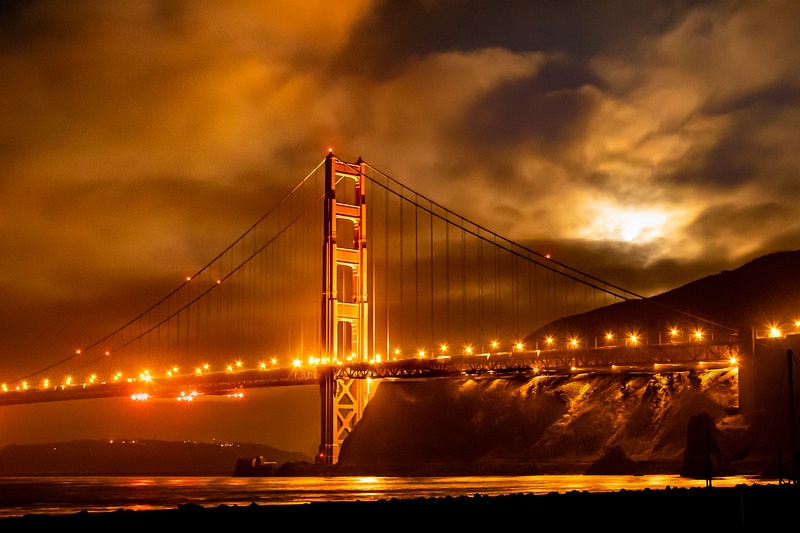 Moon over Golden Gate Bridge obscured by fog.