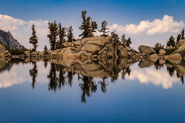 Lone Pine Lake along the Mount Whitney Trail in California's Eastern Sierra, with granite formations and pine trees reflected in calm mountain water.