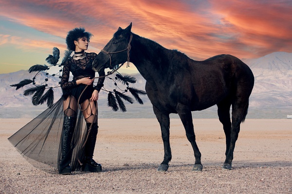 Model wearing black feathers with black horse in Nevada desert at sunrise by Rick Ferro - Rick & Rick Photo Workshops 