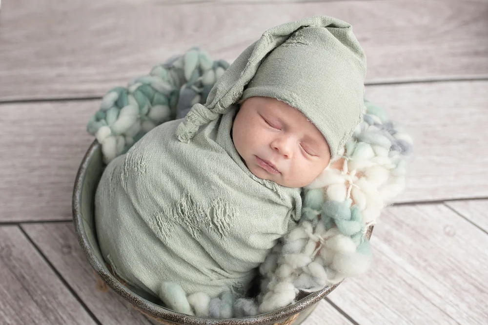 Newborn Baby Wrapped in Soft Green Fabric