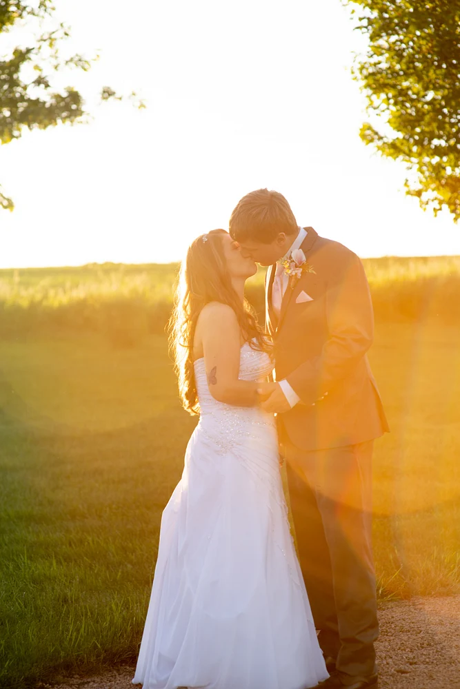 Romantic Sunset Wedding Kiss in Rural Setting
