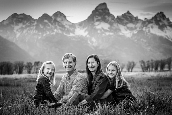 Black&amp; white family portrait sitting in field with Tetons - Flo McCall Photography 