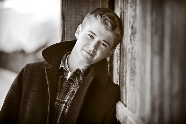 boy leaning on barn door - Flo McCall Photography