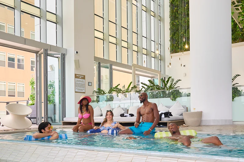 lifestyle Campaign Sentral Residential : Relaxing Poolside Retreat in Sentral Michigan Group of friends enjoying a relaxing day by the indoor pool in Central Michigan.