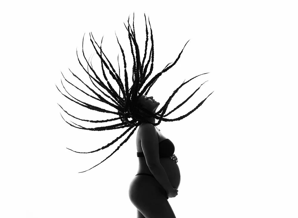 Stunning Silhouette of a Pregnant Woman with Flowing Dreadlocks