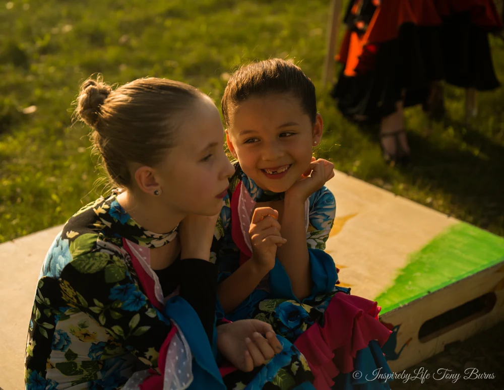 Joyful Girls in Colorful Dance Costumes Two joyful girls in colorful dance costumes sharing a moment outdoors.