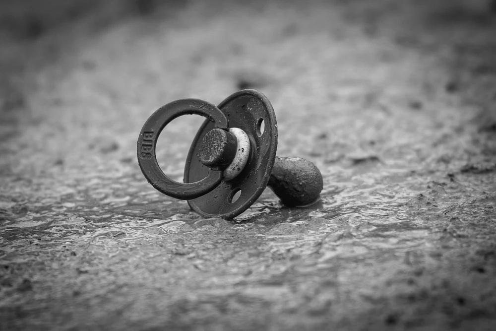 Abandoned Pacifier on Wet Ground
