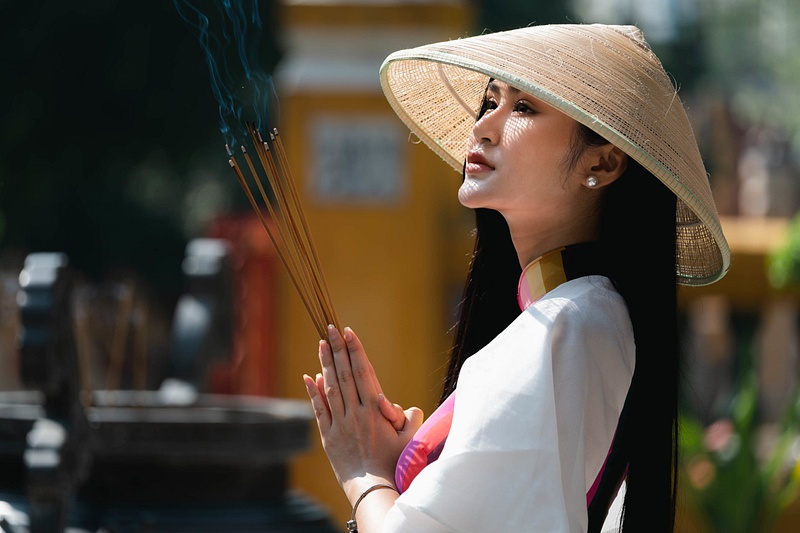Vietnamese woman worshipping at a temple in Ho Chi Minh City, Vietnam