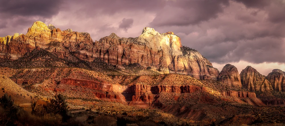Dramatic view of Mt. Kinesava and The West Temple in Zion National Park during sunset.