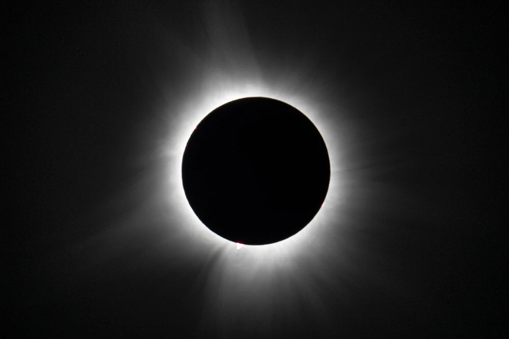 A captivating image of a solar eclipse in 2024 showing a dark moon silhouette surrounded by a radiant corona.