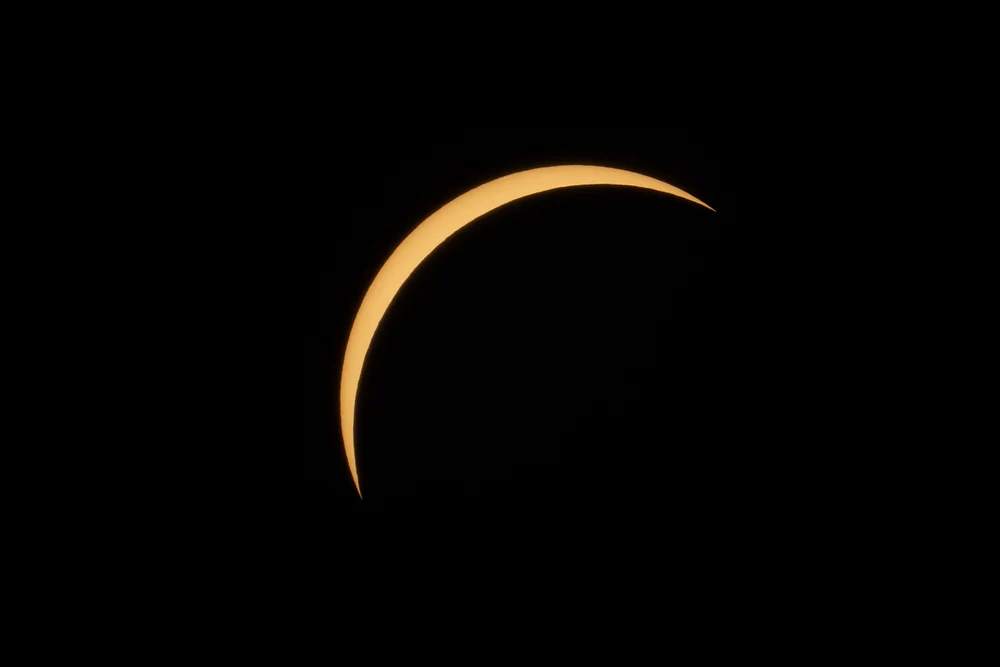A stunning crescent shape during the solar eclipse in 2024 against a dark background.