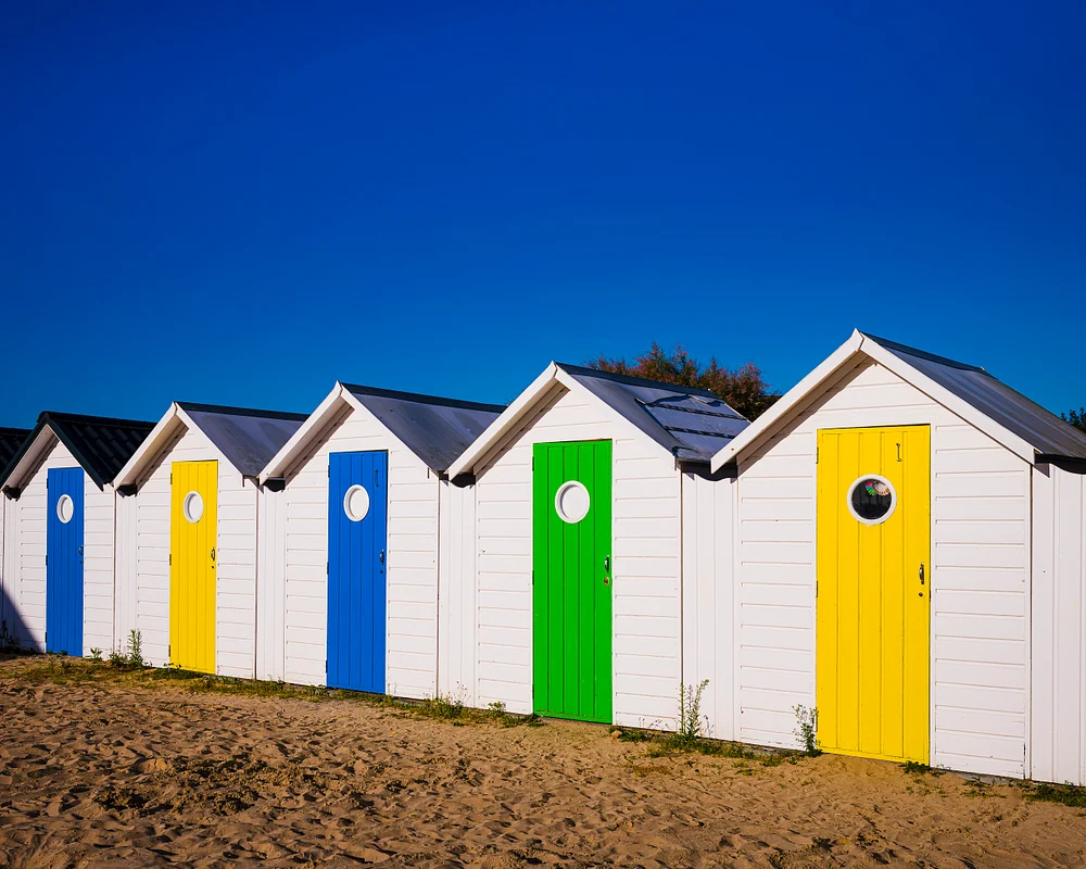 Colorful Beach Huts Under a Clear Blue Sky