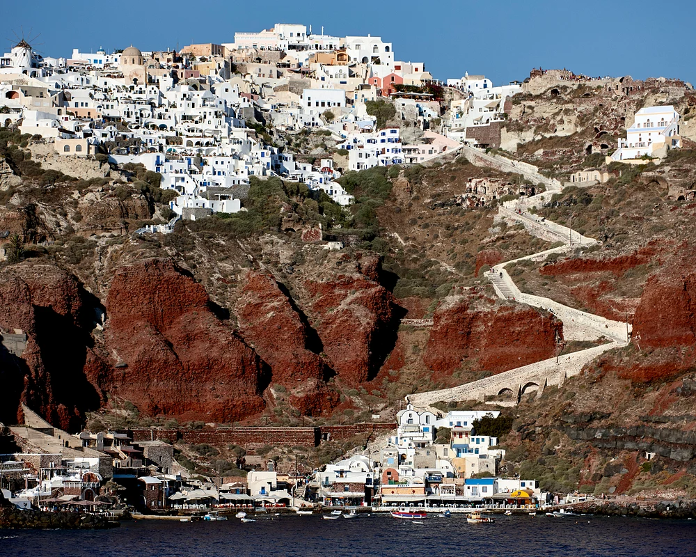 Landscape view of Oia in Santorini, Greece, featuring white buildings and dramatic cliffs.