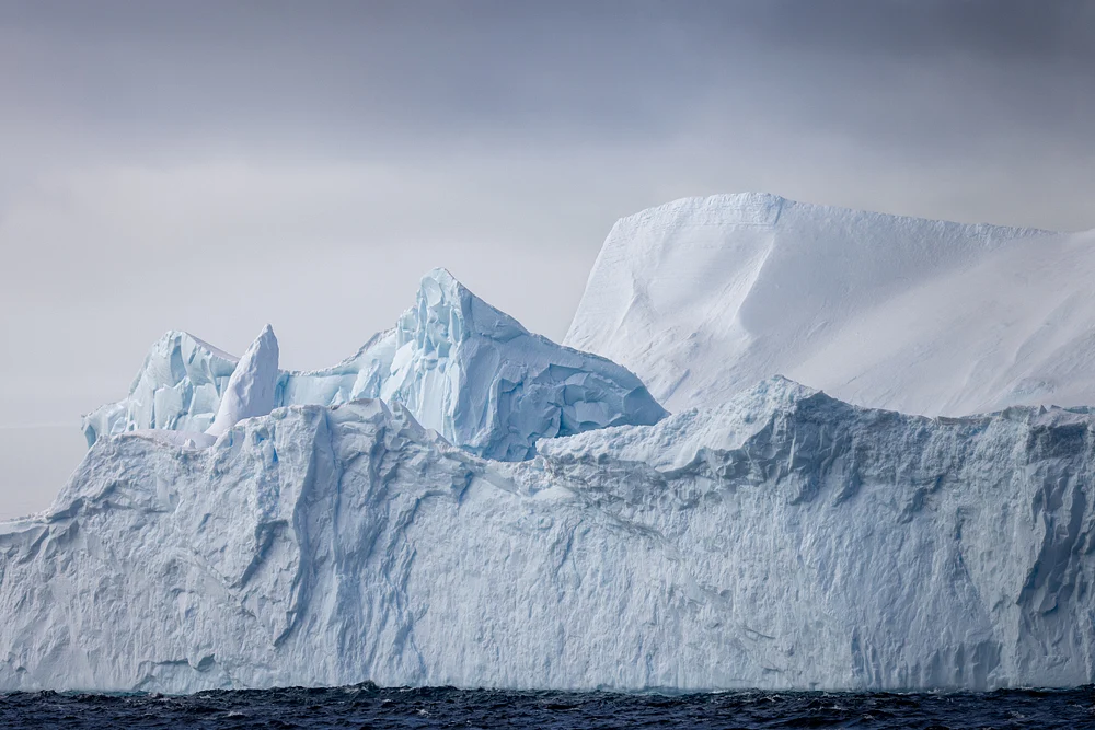 Majestic Icebergs Towering Over Ocean Waters