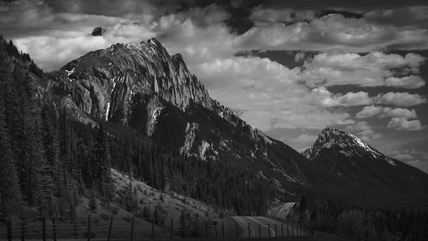 Scenic view of Kananaskis Parkway in Alberta, Canada, featuring mountains and lush forests.
