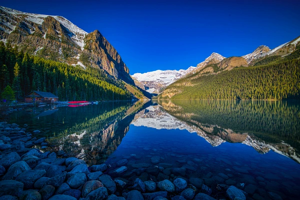 Scenic view of Lake Louise in Banff National Park, reflecting mountains and trees.