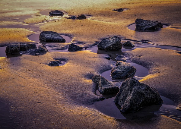 Driftwood Beach on Jekyll Island, Georgia, featuring driftwood and a colorful sunset.