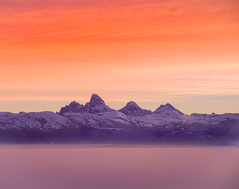 Radiant Dawn Over Snowy Peaks