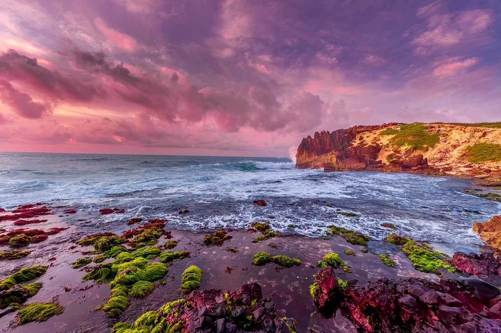 Vibrant Coastal Sunset Over Rugged Shoreline